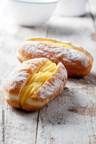 Two Bismarck doughnuts filled with pudding, close-up