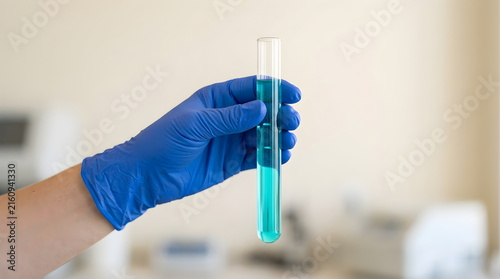 Gloved Scientist Holding Test Tube with Turquoise Liquid in Laboratory