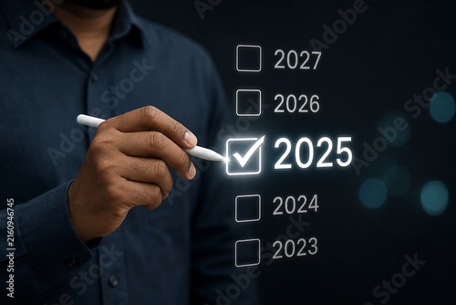 Hand checking 2025 on a list of years with glowing digital effect