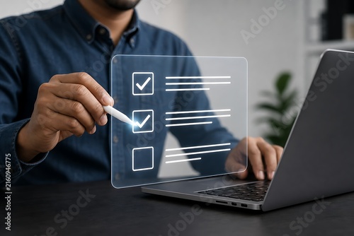 Hand checking off digital checklist on transparent screen over laptop