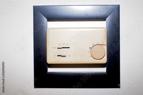 close up of old dirty ac control panel mounted on the wall