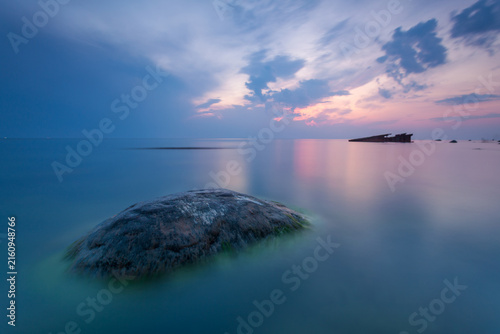 Canvas Print Calm sunrise seascape with rocks and shipwreck
