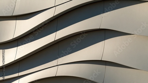 Abstract modern building facade with flowing wave-like panels and strong shadow lines