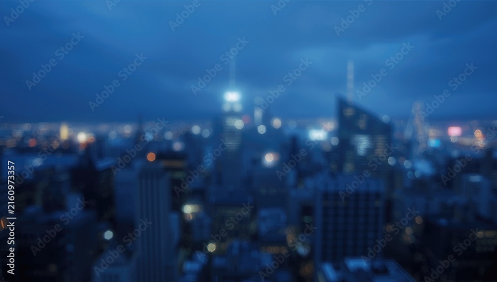 Fototapeta premium Blurry City Skyline at Dusk with Blue Tones and Urban Lights