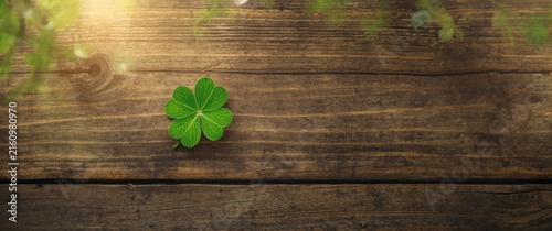 Four Leaf Clover on Wooden Table Surrounded by Nature Light