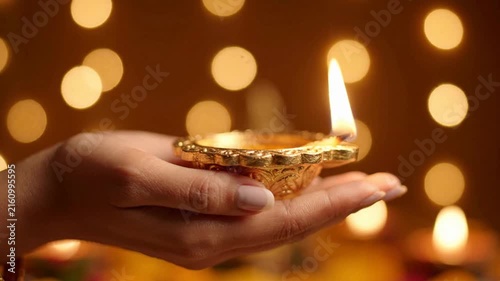 Woman holding lit diya lamp for diwali festival