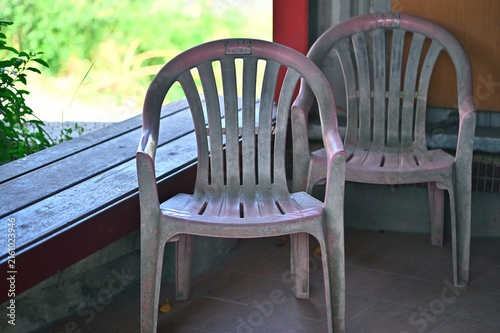 Foto Two polypropylene armchairs show severe UV chalking and whitening beside a worn wooden bench, Yuanshan Township, Yilan County, material degradation record