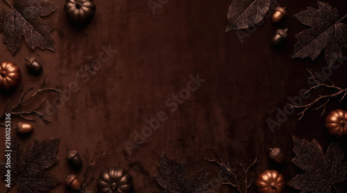 Autumn leaves and acorns border on dark brown textured background, flat lay