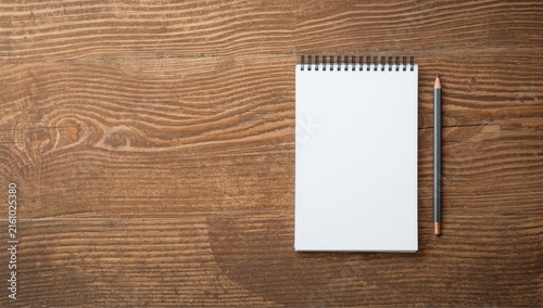 Blank Notepad with Pencil on Wooden Surface in Minimalist Setting