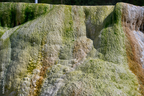 Fotografie Close-up texture of mineral water flow and limestone travertine deposit at salt