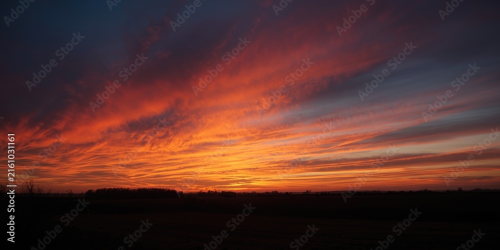 Fototapeta premium Vibrant Sunset Sky with Dramatic Clouds over Horizon at Dusk