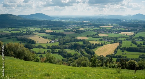 Lush Green Valley Landscape with Rolling Hills Under Cloudy Sky