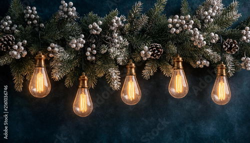Christmas garland with pine branches, silver berries, pinecones and hanging vintage light bulbs