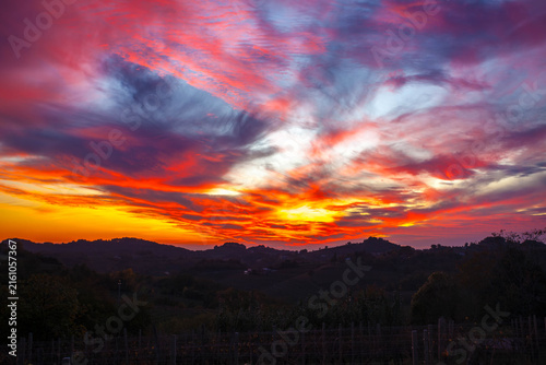 Sunset sky blazing red and orange colors over dark rolling hills and vineyards in the Collio Region, Friuli, Italy