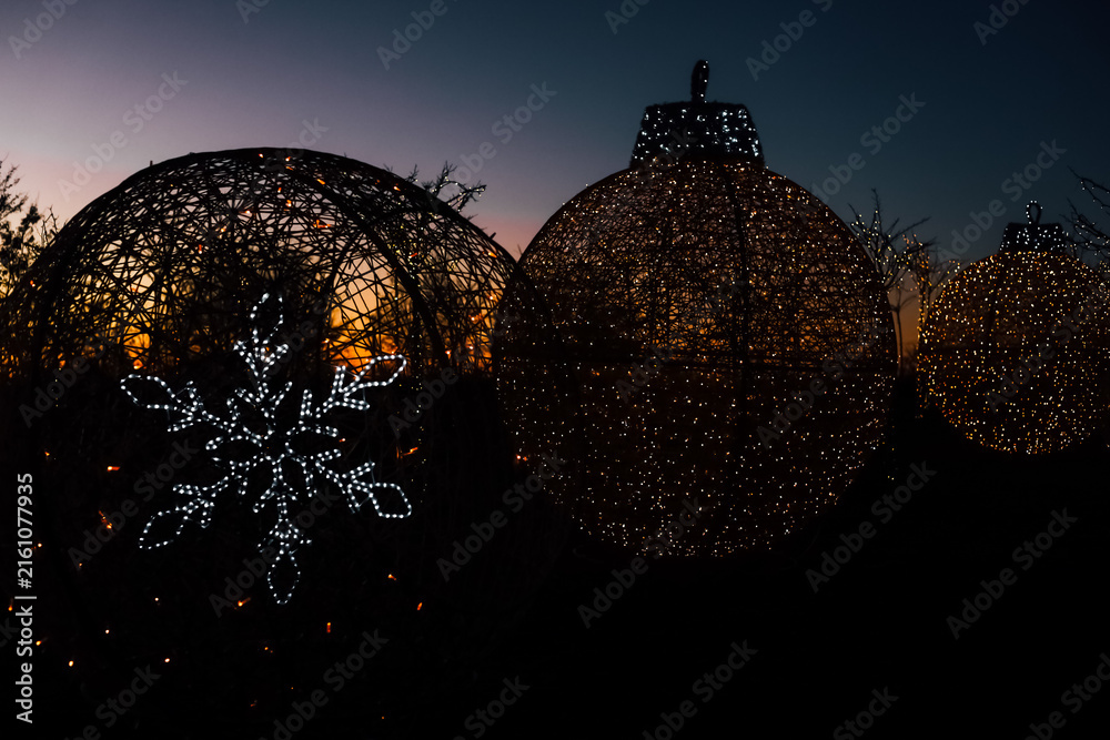 Obraz premium Bright Christmas lights on decorations at sunset during a holiday display in a public garden