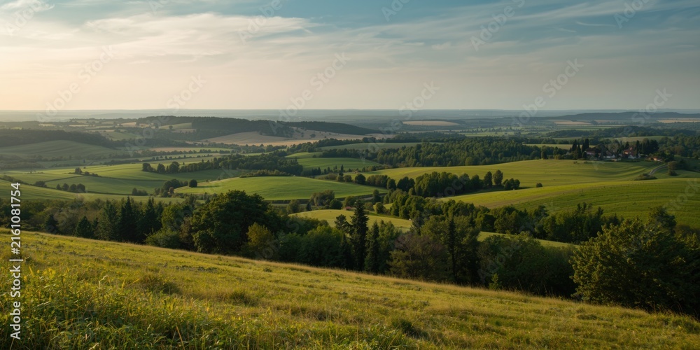 Obraz premium Lush Green Countryside Landscape with Rolling Hills Under Clear Sky
