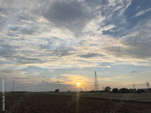 Fotografía Dramatic sunset sky over rural countryside with electricity pylon and cirrus clo