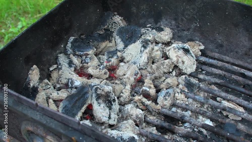 Smoldering coals on an outdoor grill after cooking meat.