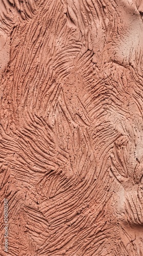 Ultra-close-up frontal view of hand-worked terracotta clay textured with delicate compressed finger grooves in organic rhythm