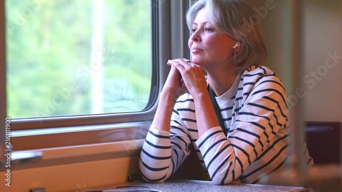 Mature Woman Passenger Looking Out Train Window During Journey - Contemplative Gaze