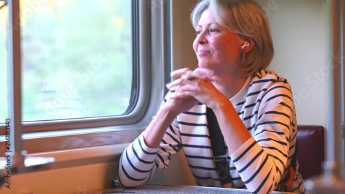 Mature woman with gray hair enjoying her journey in train.