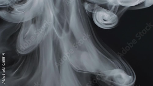 Abstract white smoke swirls on black background with soft curling patterns and flowing vapor texture