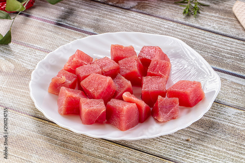 Obraz na płótnie Fresh tuna cubes on white plate over rustic wood