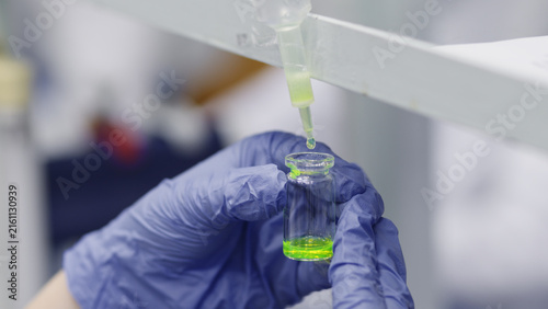 Fotografía Drop filtration of green luminescent protein in liquid and collection in a glass vial