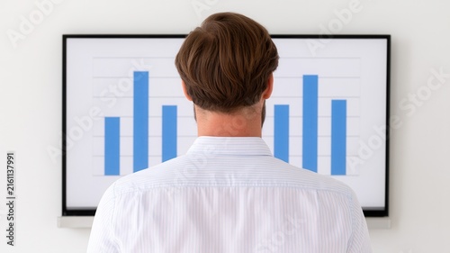 Business professional viewing a financial chart on a large screen, representing data analysis, corporate strategy, performance measurement, financial planning, leadership, growth, and decision making.