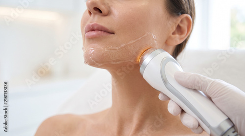 Ultrasonic skin scrubber gliding across a woman's cheek during a deep cleanse