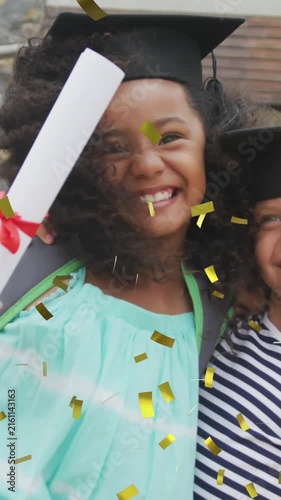Animation of gold confetti over happy diverse schoolgirls with diplomas and mortar boards embracing