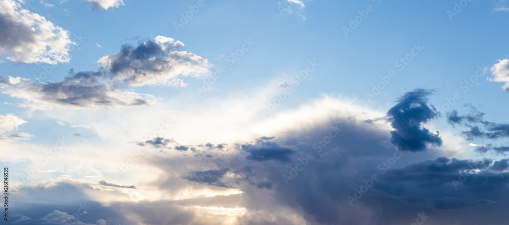 Obraz premium Blue sky with clouds and bright sunbeams breaking through