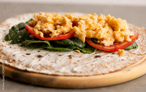 Whole Wheat Breakfast Wrap Assembly with Cream Cheese, Spinach, Tomatoes, and Scrambled Eggs