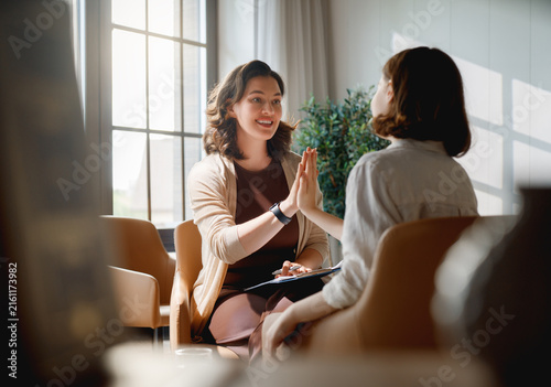 Supportive Female Therapist and Young Client in Light-Filled Office
