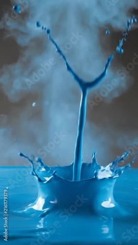 Vibrant blue paint splashing dramatically against a dark studio background