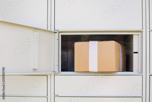 Obraz na płótnie Cardboard parcel inside an open compartment of an automated parcel locker ready for customer pickup