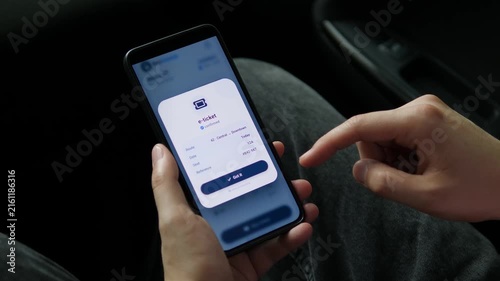Passenger checks a bus timetable and purchases an electronic ticket on a smartphone, reflecting cashless transit, connected cities and convenient digital commuting.