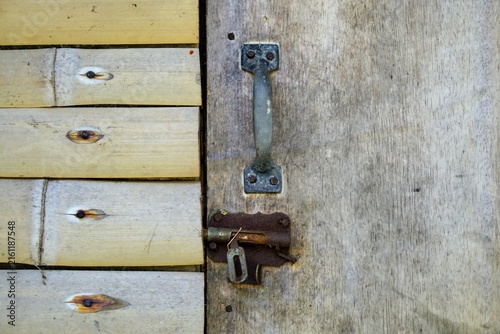 Fotografie Close up detail of an old metal door handle and rusty latch on a traditional wooden and bamboo door