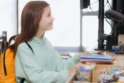 Foto Delightful schoolgirl enjoys selecting supplies in vibrant stationery store