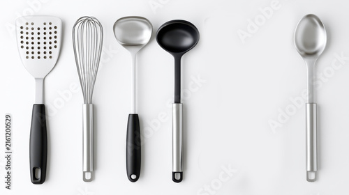 A collection of kitchen utensils, including a spatula, whisk, ladle, and spoon, laid out neatly