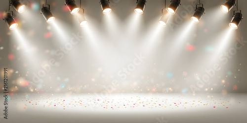 Bright white event stage with overhead spotlights and colorful confetti, creating a clean festive background for celebrations and presentations.