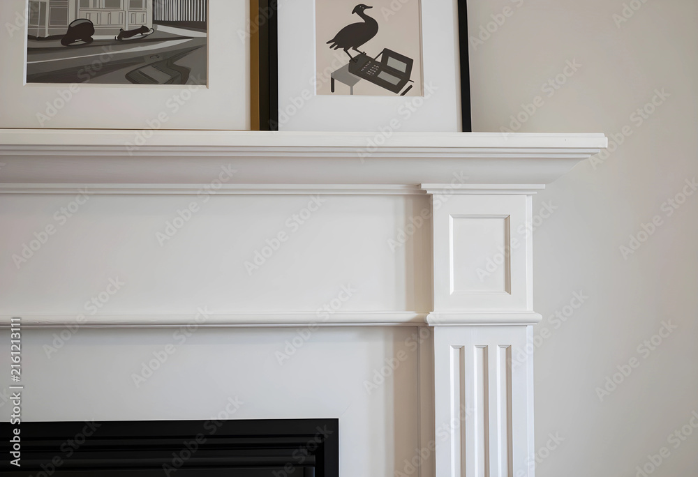 Fototapeta premium Home interior design and decor, white fireplace mantel with framed artwork, modern living room architecture detail