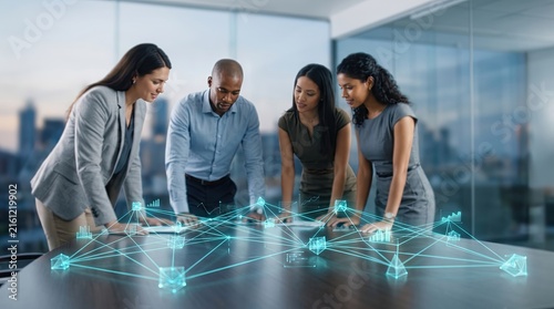 A diverse team collaborates over digital data visualization in a modern office setting, enhancing strategic insights.