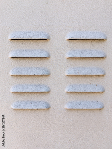Metal ventilation louvers on beige cabinet surface industrial production