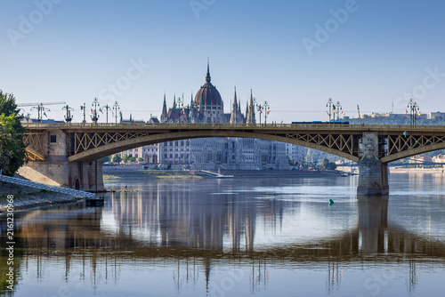Margaret Bridge spanning the Danube River in Budapest, Hungary, with the iconic Hungarian Parliament Building in the background.