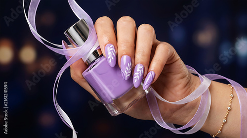 Hand holding purple nail polish bottle with brush extended