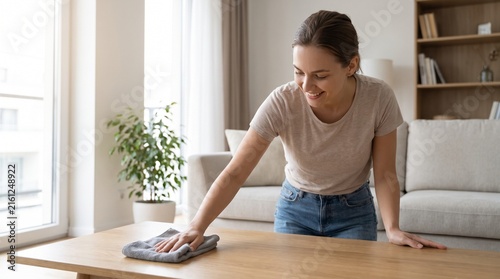 Young Adult Wiping a Wooden Surface in a Bright Modern Living Room