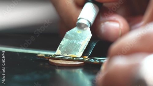 Technician repairing a laptop connector with precision tools close up detail workbench