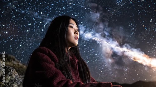 Woman gazing at a spectacular starry night sky and Milky Way, creating a peaceful moment of wonder and connection with nature