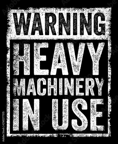 WARNING HEAVY MACHINERY IN USE grunge sign featuring distressed capital letters inside a textured layout for industrial safety and caution themes.